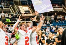 
			
				                                Mason Palmer (2) carries the state championship trophy. (Photo by Cameron Carlson)
 
			
		