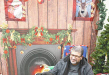Devils Lake Chamber hosts reception at LRAC
Early on, Norm, a Newf0undland dog, acted as greeter at the LRAC. Here he welcomes a pat from Mark C. Robinson, Managing Editor of the Devils Lake Journal. (Photo by Louise Oleson, DLJ editor)
