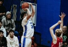 
			
				                                Four Winds/Minnewaukans Sonny Alberts lines up a three-point attempt with Devils Lakes Egan Laite guarding him. (Photo by Cameron Carlson)
 
			
		