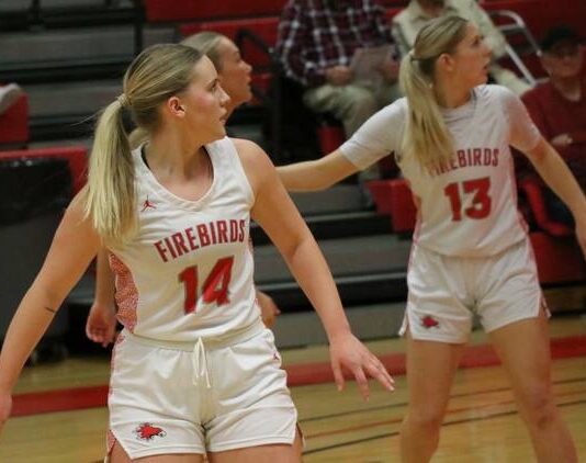 
			
				                                Jenae Martinson (14) and Tylie Brodina (13) turn their heads while watching a play commence farther down the court. (Photo by Mojo Hill)
 
			
		