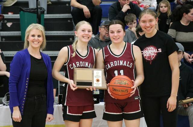 Langdon Area/Munich players Hilary Haaven, Erika Bakke and Aubrey Badding accept the Cardinals District 4 runner-up award.
