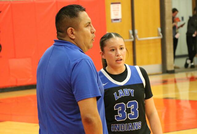 Head coach Sean Gourd Sr. talks with daughter Suri Gourd during a break in the action of Four Winds/Minnewaukans semifinal game against Carrington on Tuesday. (Photo by Mojo Hill)