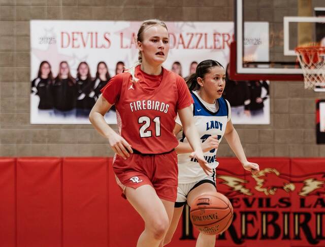 132166274_web1_presley-brown-suri-gourd-2-26-26
Presley Brown dribbles the ball for Devils Lake with Four Winds/Minnewaukans Suri Gourd trailing behind her. (Photo by Cameron Carlson)