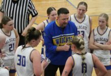 
			
				                                Benson County head coach Bryan Kenner gives his team a pep talk during a timeout. (Photo by Mojo Hill)
 
			
		