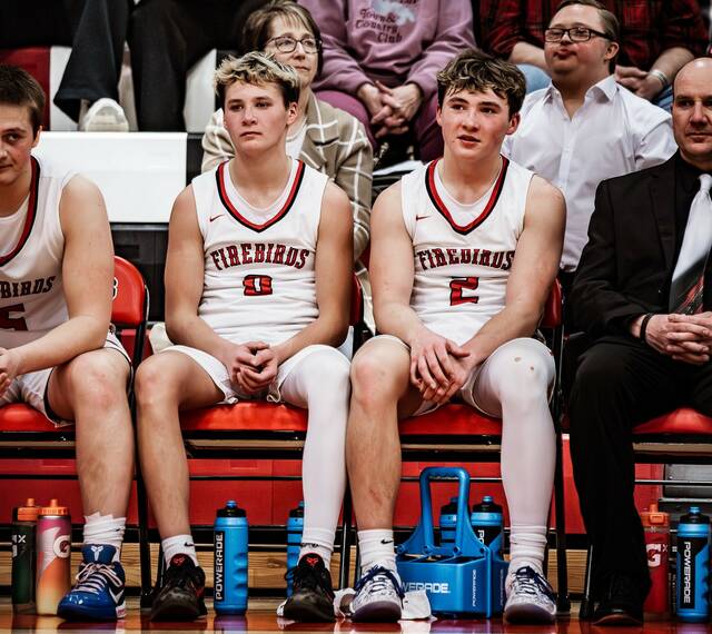 Devils Lakes Mason and Max Palmer watch from the bench as the Firebirds battle Thompson in their regular-season finale. (Photo by Cameron Carlson)