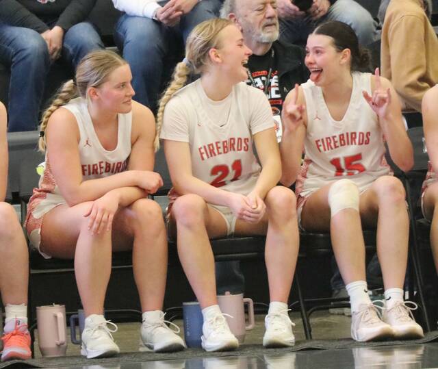 Left to right: Jenae Martinson, Presley Brown and Mia Elsperger sit on the bench immediately after winning the state seventh-place game at the Devils Lake Sports Center. (Photo by Mojo Hill)