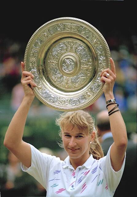 Steffi Graf, seen here in a happier time in this July 4, 1992 file photo as she laughs holding the ladies singles trophy on Wimbledons Centre Court after defeating Monica Seles 6-2, 6-1, to win her fourth Wimbledon championship in London. Seles had previously ended her 186 week-streak as the No. 1 womens tennis player in 1991. (AP Photo/Dennis Paquin)