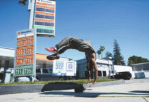 
			
				                                Marcus Hopkins, a street performer, does a backflip in front of advertised gas prices Monday, March 9, 2026, in Los Angeles. (AP Photo/Damian Dovarganes)
 
			
		