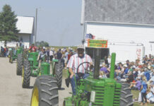 
			
				                                This vintage John Deere tractor, leading the parade of tractors in a Stump Lake Village Threshing Bee parade, has the narrow twin wheels on the front of the tractor. (Photo by Louise Oleson, DLJ)
 
			
		
