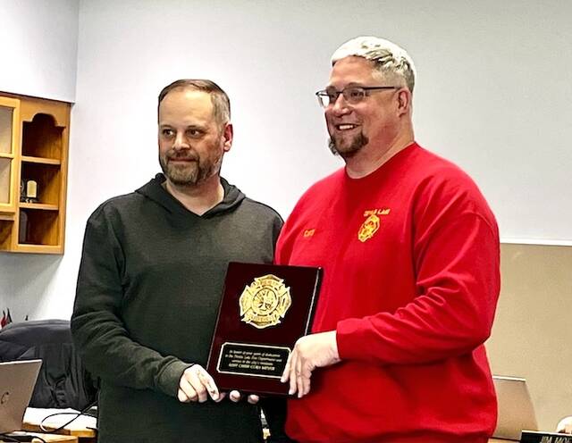 At the Devils Lake City Commission meeting on Monday, March 16, Commissioner Jason Pierce presents Asst. Fire Chief Cory Meyer with a plaque commemorating his years of service with the Devils Lake Fire Department.