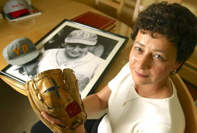 Maria Pepe poses with the glove she used to play in Little League baseball, Thursday, Nov. 6, 2003, in her Hoboken, N.J., apartment. In the background a photo of her in her uniform can be seen next to her Young Democrats team hat. Pepe only got to play three Little League games for her Hoboken team in 1972, but it was the lawsuit brought in her name and decided over 50 years ago that opened Little League to millions of girls everywhere.
                                 AP Photo/Christopher Barth
