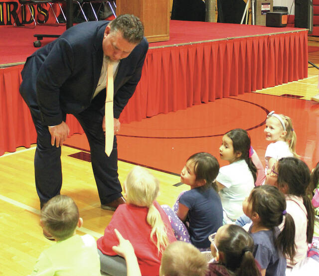 Devils Lake Public Schools Superintendent Ned Clooten takes time with kindergarten students before the presentation of the Teacher and Support Staff of the Year awards at the school assembly in the Devils Lake High School Sports Center gymnasium.
                                 Photo by Mark C. Robinson