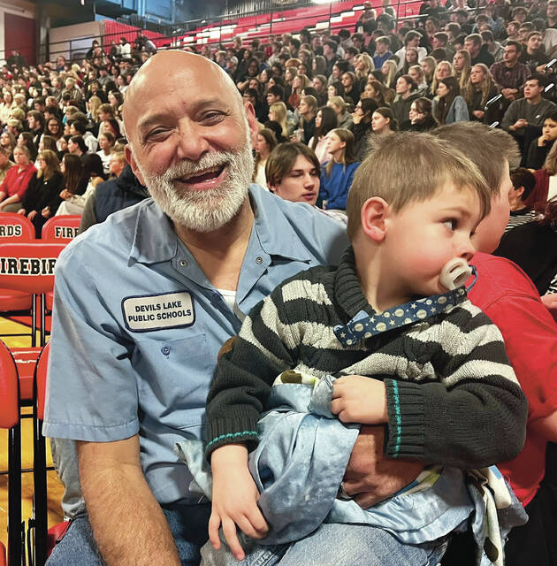Devils Lake High School custodian Todd Dauphinais posing with his son Dion after being chosen as Support Staff of the Year on Wednesday afternoon, April 1, at the school assembly in the Devils Lake High School Sports Center gymnasium.
                                 Photo by Mark C. Robinson