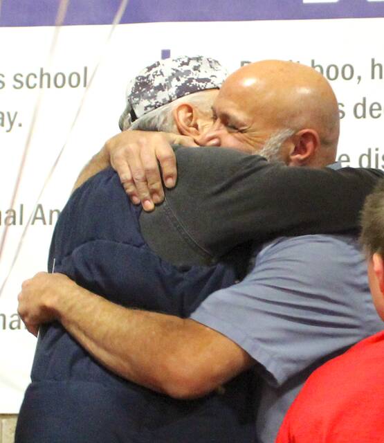 Devils Lake High School custodian Todd Dauphinais embraces a family member after being chosen as Support Staff of the Year on Wednesday afternoon, April 1, at the school assembly in the Devils Lake High School Sports Center gymnasium.
                                 Photo by Mark C. Robinson