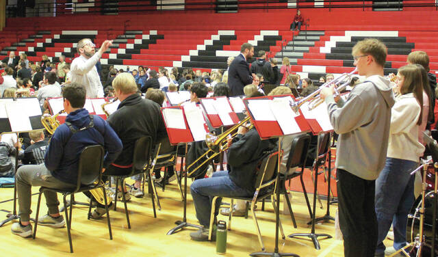 Conductor Jeremiah Johnson leads the school orchestra at the assembly in the Devils Lake High School Sports Center gymnasium on April 1. (Photo by Mark C. Robinson)
                                 Photo by Mark C. Robinson