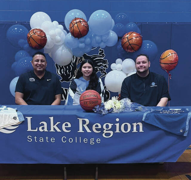 Dru Longie sits between Four Winds head coach Sean Gourd Sr. (left) and LRSC athletic director Colden Hutton (right).
                                 Photo courtesy of Four Winds Sports