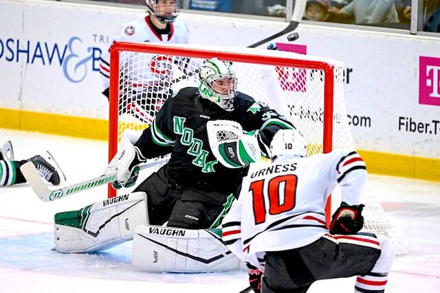 FILE - North Dakota goaltender Jan Spunar, left, deflects a St. Cloud State shot as forward Noah Urness (10) looks during the first period of an NCAA college hockey game, Dec. 6, 2025 in St. Cloud, Minn.
                                 AP Photo/Craig Lassig, File