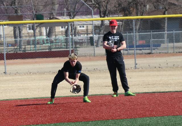 Max Palmer fields a ground ball as twin Mason Palmer stands beside him.
                                 Photo by Mojo Hill