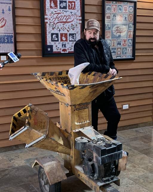 Stormare poses with the woodchipper prop from the movie Fargo at the visitors center in West Fargo.
                                 Photo courtesy of Fargo Theatre