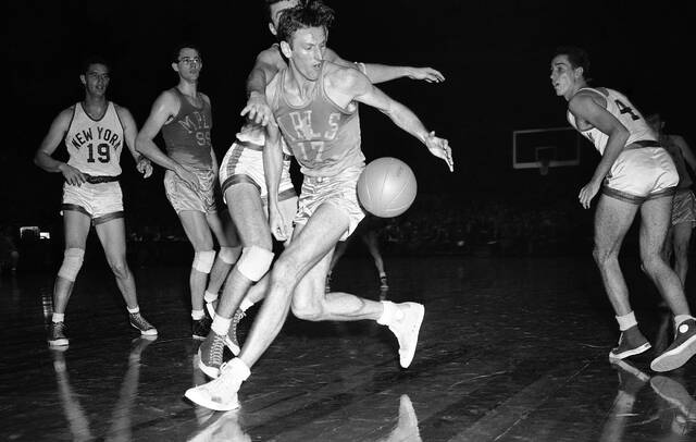 Jim Pollard (17) of the Minneapolis Lakers reaches for a loose ball in second quarter of game against the New York Knickerbockers in Madison Square Garden in New York on Nov. 11, 1948. At left are Lee Knorek (19) of the Knicks and George Mikan (99) of the Lakers. Minneapolis won 77 to 68. A year and a half later on April 23, 1950, The Minneapolis Lakers would become the first team to win back-to-back NBA championships.
                                 AP Photo/Marty Lederhandler