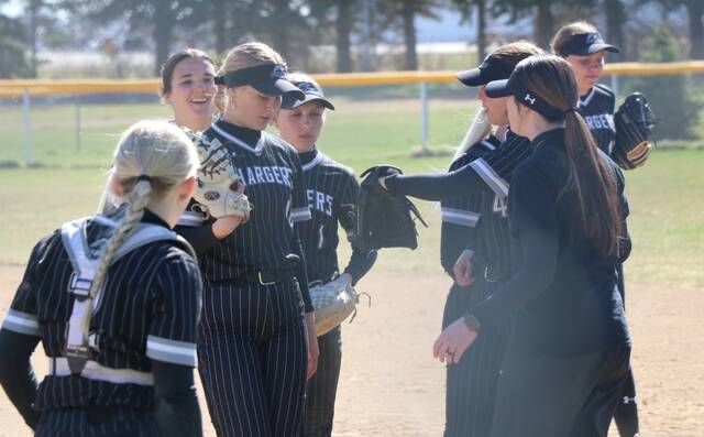 The Nelson County/Midkota softball team meets by the first-base sideline during in between innings of a game in McVille.
                                 Photo by Mojo Hill