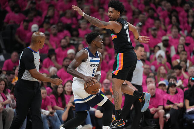 Minnesota Timberwolves guard Anthony Edwards (5) handles the ball as San Antonio Spurs guard Dylan Harper (2) defends during the first half in Game 1 of a second-round NBA playoffs basketball series in San Antonio, Monday, May 4, 2026.
                                 AP Photo/Eric Gay