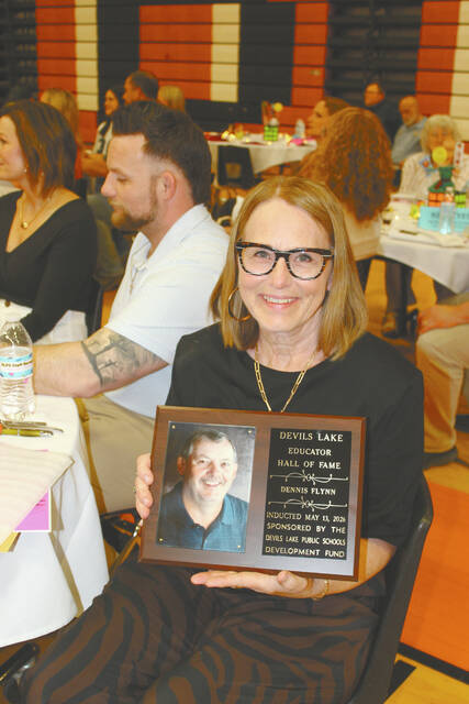 Dennis Flynn was inducted into the Educator Hall of Fame posthumously with his wife, Bette, accepting his plaque and thanking those responsible for this honor. The program notes from his induction stated, He was the kind of teacher and coach that believed that every child mattered. He would go above and beyond for students and athletes, encouraging them to be the best that they could possibly be. Flynn was in his 18th year at Devils Lake when he unexpectedly passed away March 20, 2007. 
                                 Photo by Louise Oleson, DLJ