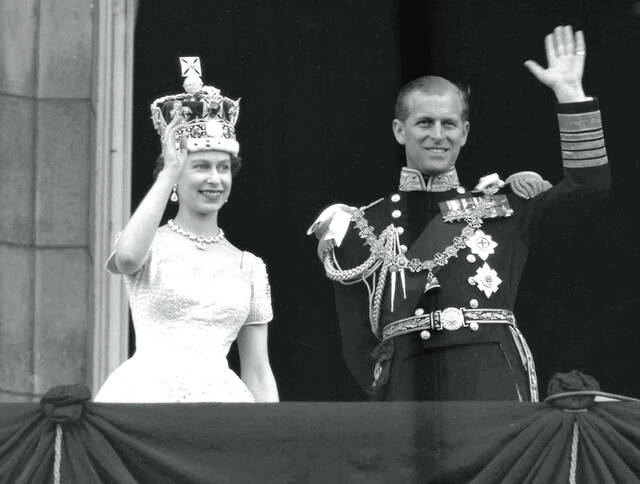 In this June. 2, 1953 file photo, Britains Queen Elizabeth II and Prince Philip, Duke of Edinburgh wave to supporters from the balcony at Buckingham Palace, following her coronation at Westminster Abbey, London. Queen Elizabeth II, Britains longest-reigning monarch and a rock of stability across much of a turbulent century, has died. She was 96. Buckingham Palace made the announcement in a statement on Thursday Sept. 8, 2022.
                                 AP Photo/Leslie Priest, File