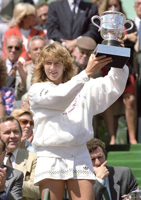 West Germanys Steffi Graf holds holds up her Suzanne Lenglen winners trophy after her victory in the French Open tennis tournament, June 4, 1988, at Paris Roland Garros Stadium. Top-seeded Graf won the womens title for the second year in row by defeating 13th seeded Natalia Zvereva of the Soviet Union 6-0, 6-0.
                                 AP Photo/Lionel Cironneau