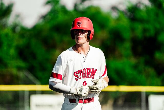 Hunter Remmick walks back to the dugout while removing his batting gloves after the end of an inning.
Photo by Noah Clooten
