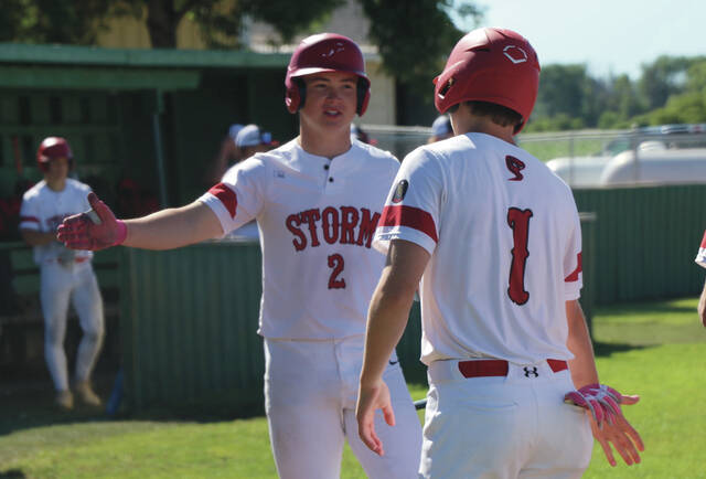 Will Heilman high-fives Mason Palmer on his way back to the dugout.