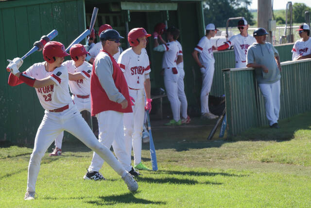 The Devils Lake dugout resets between half-innings, preparing to take its turn at bat.
