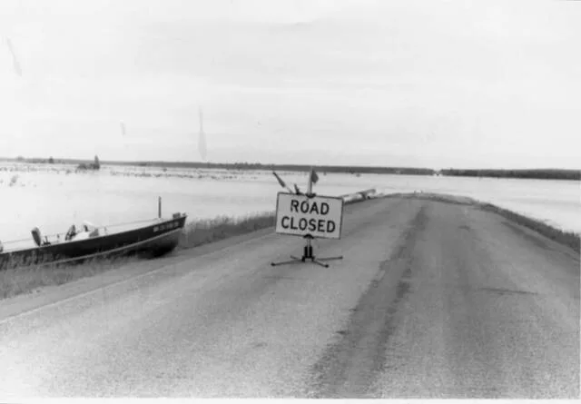 The cutline to go with this photo was titled Escape from Grahams Island showing the only road into (and out of) the Devils Lake State Park at Grahams Island impassable due to flooding. This road, which leads to the park and local farms, had to be raised more than once during the height of Devils Lake flooding.