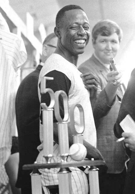 Atlanta Braves slugger Hank Aaron grins over his huge trophy presented by Braves President Bill Bartholomay, after Aaron hit his 500th career home run on July 14, 1968, in Atlanta, Ga. The milestone home run ball rests atop the trophy. Aaron, who endured racist threats with stoic dignity during his pursuit of Babe Ruth but went on to break the career home run record in the pre-steroids era, died on Jan. 22, 2021, at age 86.