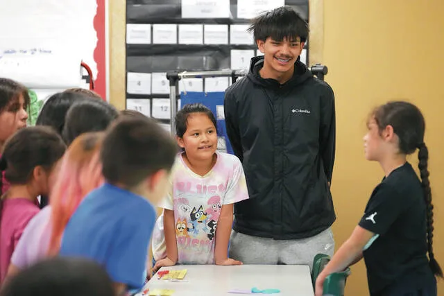 Chief Leschi Schools senior Gerald Dillon, 18, who serves as a teaching assistant through the schools career and technical education program, listens to a second grade student describe the parts of their Play-Doh insect in class Wednesday, March 18, 2026, at Chief Leschi Schools in Puyallup, Wash.
                                 AP Photo/Lindsey Wasson