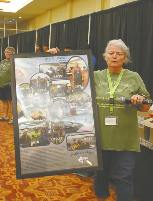 Dawn Hamre holds one of the three photo collages made up in honor of long-time volunteer Leroy Weber who passed away earlier this year. Two of these collages went home with Webers family and the third? Well that may end up in a special hall of fame someday, perhaps.