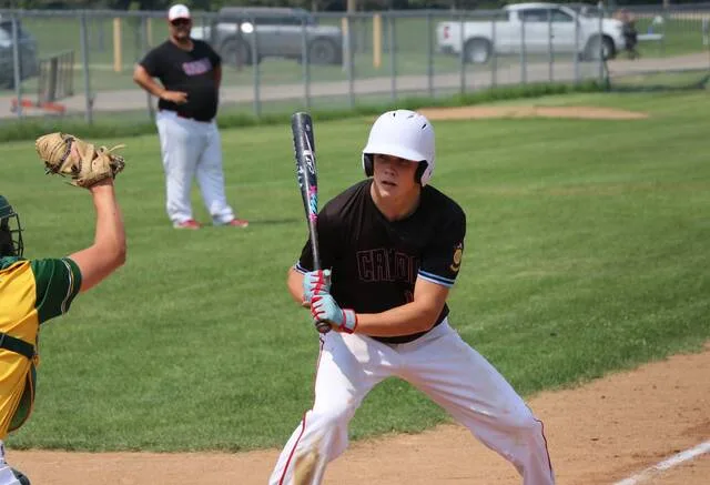 Candos Kale Prouty looks back at the Rolla catcher after taking a pitch during the first round of Legion postseason play at the Lumberyard in Bottineau.
                                 Photo by Mojo Hill