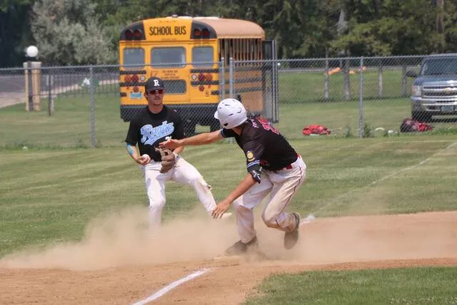 Hunter Hagler slides into third base after hitting a triple during a district elimination game against Rugby at the Lumberyard in Bottineau.
                                 Photo by Mojo Hill