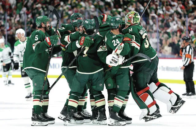 Minnesota Wild players celebrate after their teams win over the Dallas Stars during overtime of Game 4 in the first round of the NHL Stanley Cup hockey playoffs Saturday, April 25, 2026, in St. Paul, Minn. The Wild will be one of four teams to have their game telecasts produced and distributed by the NHL for the upcoming season.
                                 AP Photo/Matt Krohn