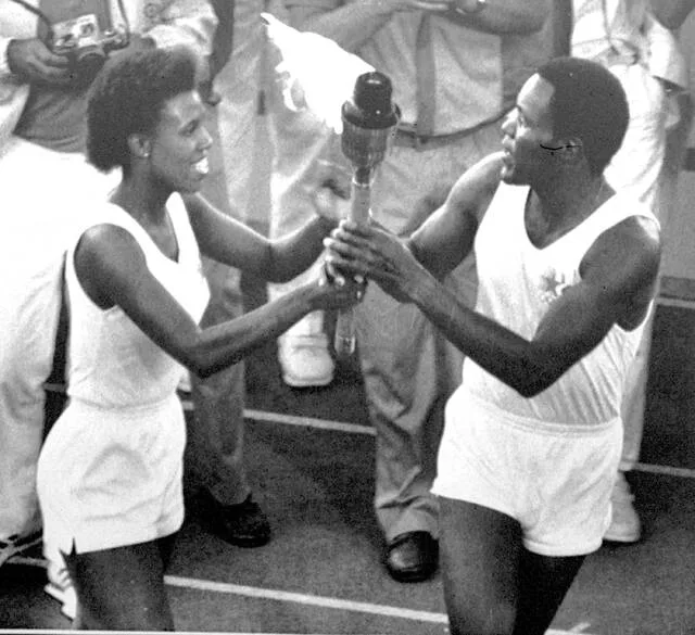Gina Hemphill, the granddaughter of Jesse Owens, the superstar at the 1936 Summer Olympics in Germany, passes the Olympic torch to Rafer Johnson, the 1960 Olympic decathlon winner, who lit the Olympic flame and formally opened the XXIII Olympiad in Los Angeles Saturday, July 28, 1984.
                                 AP Photo, file