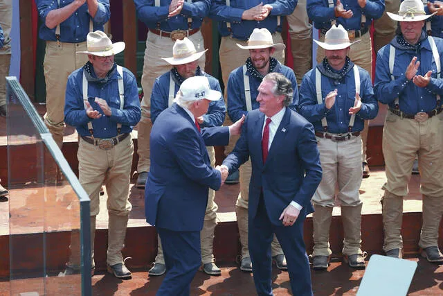 President Donald Trump greets Interior Secretary Doug Burgum July 1, 2026, at the Burning Hills Amphitheatre in front of Rough Riders reenactors.
Photo by Kyle Martin/For the North Dakota Monitor