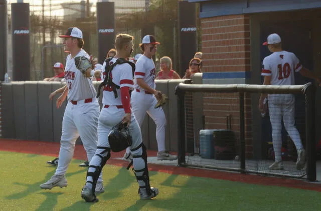 Catcher Ben Brodina receives a high-five from Landon Sundeen as he retreats to the dugout.