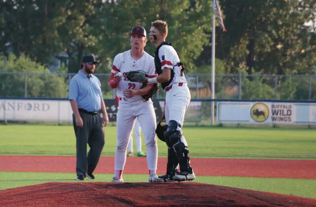 Pitcher Cayden McCarthy and catcher Ben Brodina deliberate on the mound between pitches.