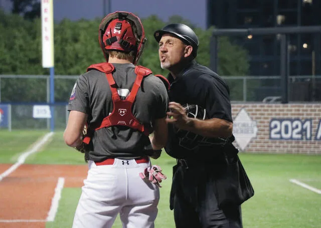 Devils Lake catcher Will Heilman chats with the home-plate umpire before the inning gets started.