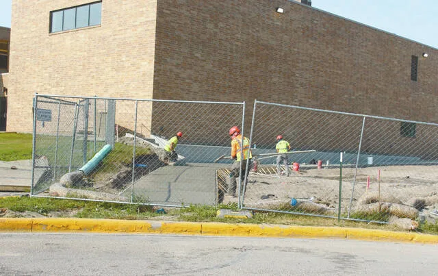 Also on the backside of CMS, workers were smoothing out freshly poured concrete for the sidewalk.