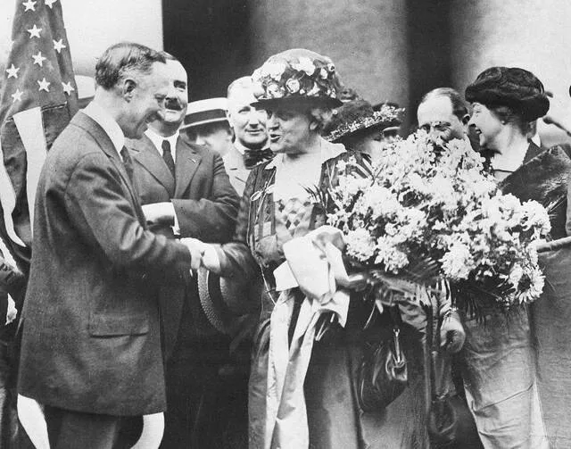 In this Aug. 27, 1920 file photo, New York Gov. Alfred E. Smith, welcomes Carrie Chapman Catt, womens suffrage leader, on her return from Tennessee, the last state to ratify the 19th Amendment giving women the right to vote, in New York. Catt carries a bouquet of blue and yellow flowers, colors of the National American Womans Suffrage Association.
                                 AP Photo