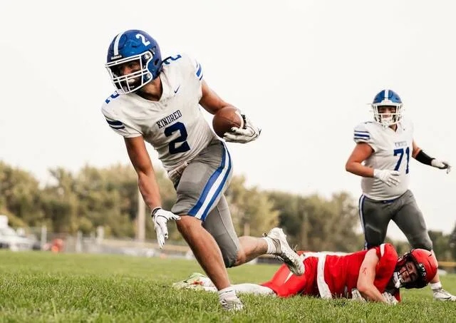 Kindreds Brooks Bakko escapes with the football as a Devils Lake player watches from the ground during the Firebirds 2026 season opener at Roller Field.
                                 Photo by Cameron Carlson