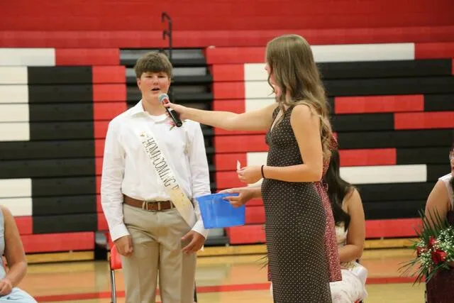 Homecoming prince Jacob Shock answers a question into the microphone in front of the crowd.