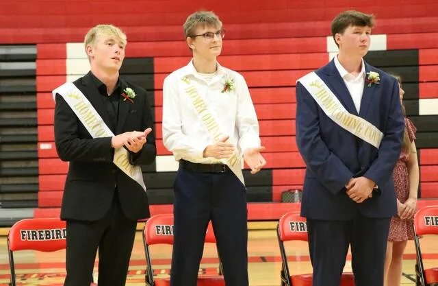 Homecoming king nominees Easton Encinas, Jonathan Kraft and Kyler Moen (left to right) stand and applaud.