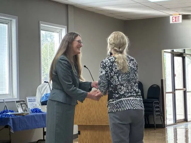 LRSC president Carmen Simone (left) greets former Lake Region basketball player Laurie Hagler Komrosky (right). She did the same for each individual member of the team in attendance.
                                 Photo by Mojo Hill